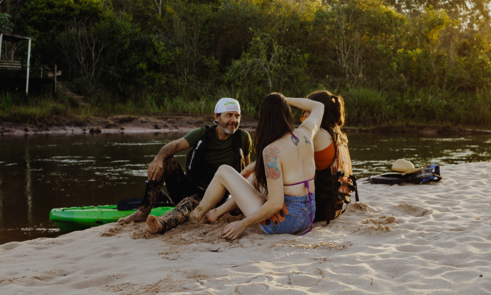 Pessoas relaxando na praia do rio